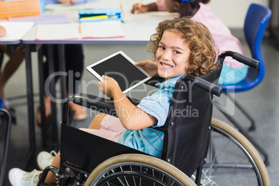 Portrait of disabled schoolboy using digital tablet