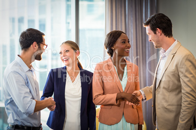 Businessmen and businesswomen shaking hands with each other
