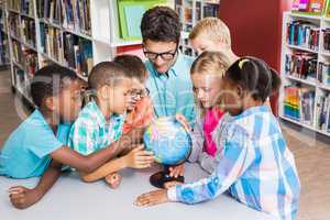 Teacher and kids discussing globe