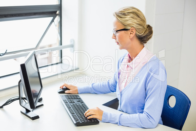 Teacher working on computer in classroom