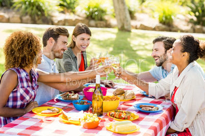 Friends toasting glasses of wine while having breakfast