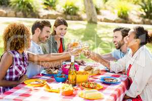 Friends toasting glasses of wine while having breakfast