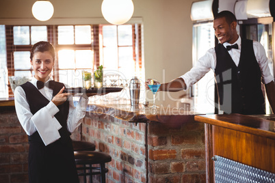 Female bartender holding a serving tray with two cocktail glass