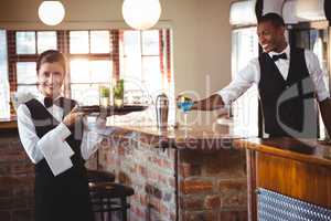 Female bartender holding a serving tray with two cocktail glass