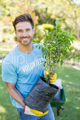 Portrait of volunteer man holding plant