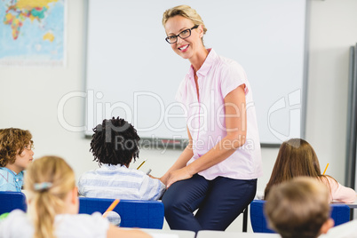 Teacher helping kids with their homework in classroom