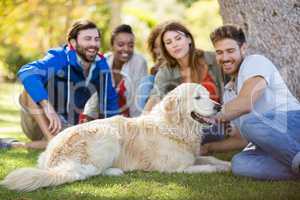 Group of happy friends sitting together with the dog