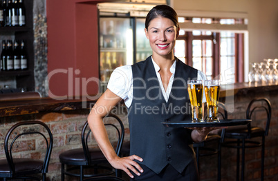 Portrait of waitress holding serving tray with two glass of beer