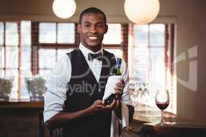 Portrait of bartender holding a wine bottle