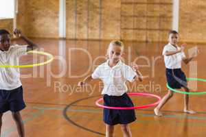 Students playing with hula hoop in school gym