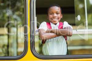 Portrait of schoolboy looking from school bus