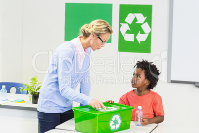 Teacher and schoolboy discussing about recycle logo