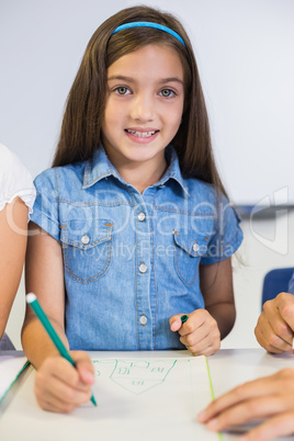 Portrait of schoolgirl drawing in book