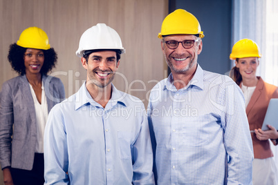 Team of smiling architects standing in office