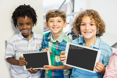 Portrait of students holding digital tablet in classroom Portrait of students holding digital tablet in classroom