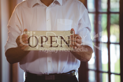 Man holding a sign with open