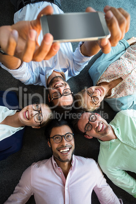 Business team lying on the floor with head together and taking s