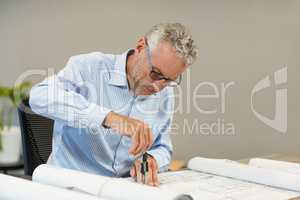 Architect working on blueprint at desk