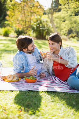 Couple toasting glasses of wine while having breakfast