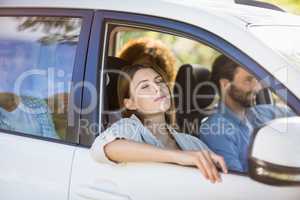 Beautiful woman relaxing in car with friends