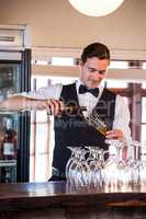 Smiling bartender pouring a beer in a glass