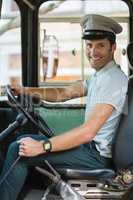 Smiling bus driver driving a bus