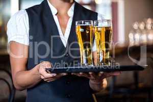 Waitress holding serving tray with two glass of beer