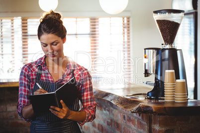 Waitress writing in a book