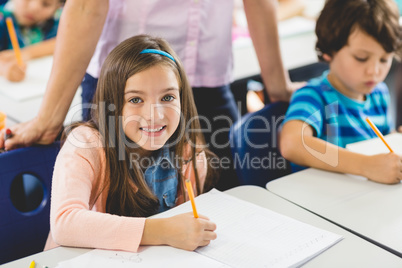 School girl doing homework in classroom