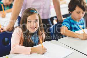 School girl doing homework in classroom