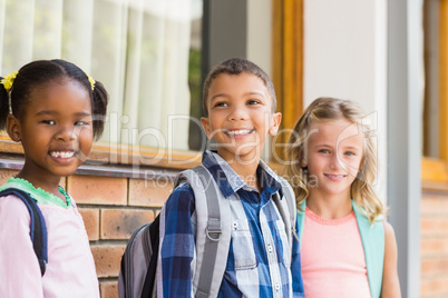 Smiling school kids standing in corridor