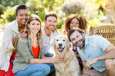 Group of happy friends sitting together with the dog