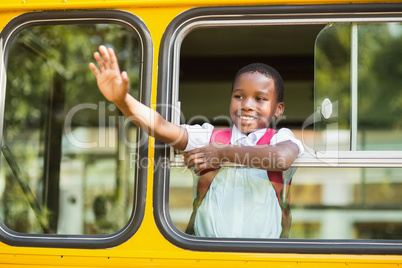 Schoolboy waving hand from bus
