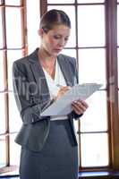 Woman writing on clipboard