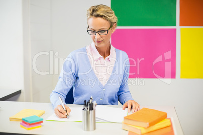 Teacher checking book in classroom