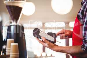 Mid section of waiter using credit card machine