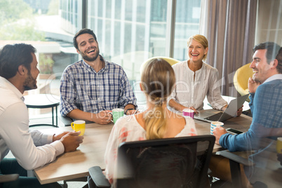 Business people holding coffee mug during a meeting