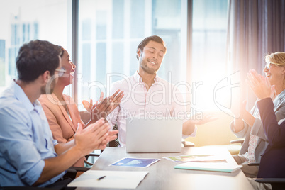 Coworkers applauding a colleague after presentation