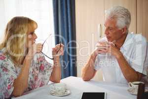 Senior couple discussing around a table