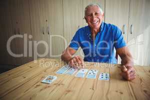 Portrait of smiling senior man pointing at a card