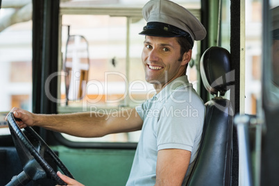 Smiling bus driver driving a bus