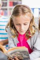 Schoolgirl reading a book in library