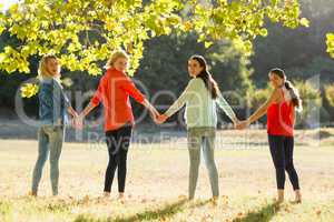 Beautiful women holding hands in park