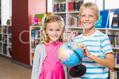 Kids holding globe in library