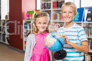 Kids holding globe in library