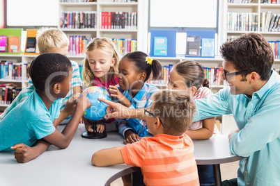 Teacher and kids discussing globe