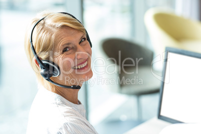 Woman working on computer with headset
