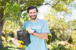 Portrait of volunteer man holding plant
