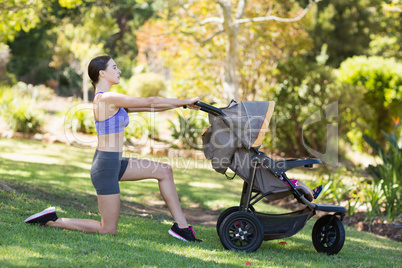 Young woman exercising with baby stroller