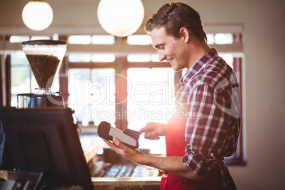 Smiling waiter using credit card machine